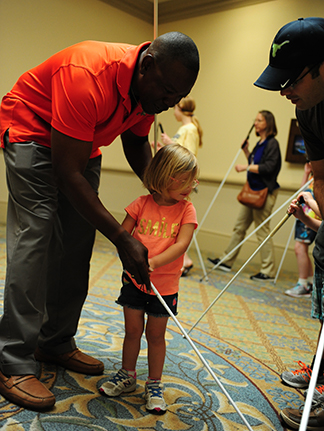 Roland Allen teaches a young girl how to hold her cane.
